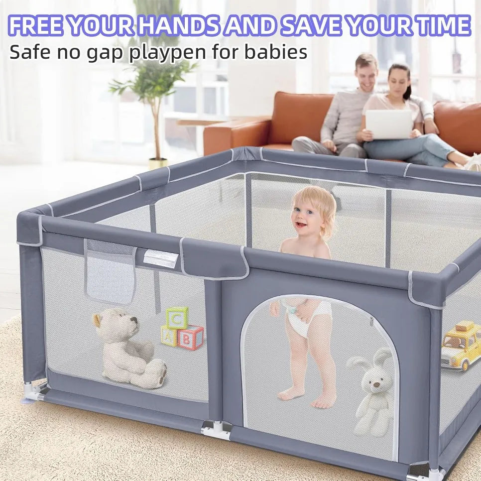 Grey mesh baby playpen with a toddler playing inside with toys, while parents sit on a sofa in the background