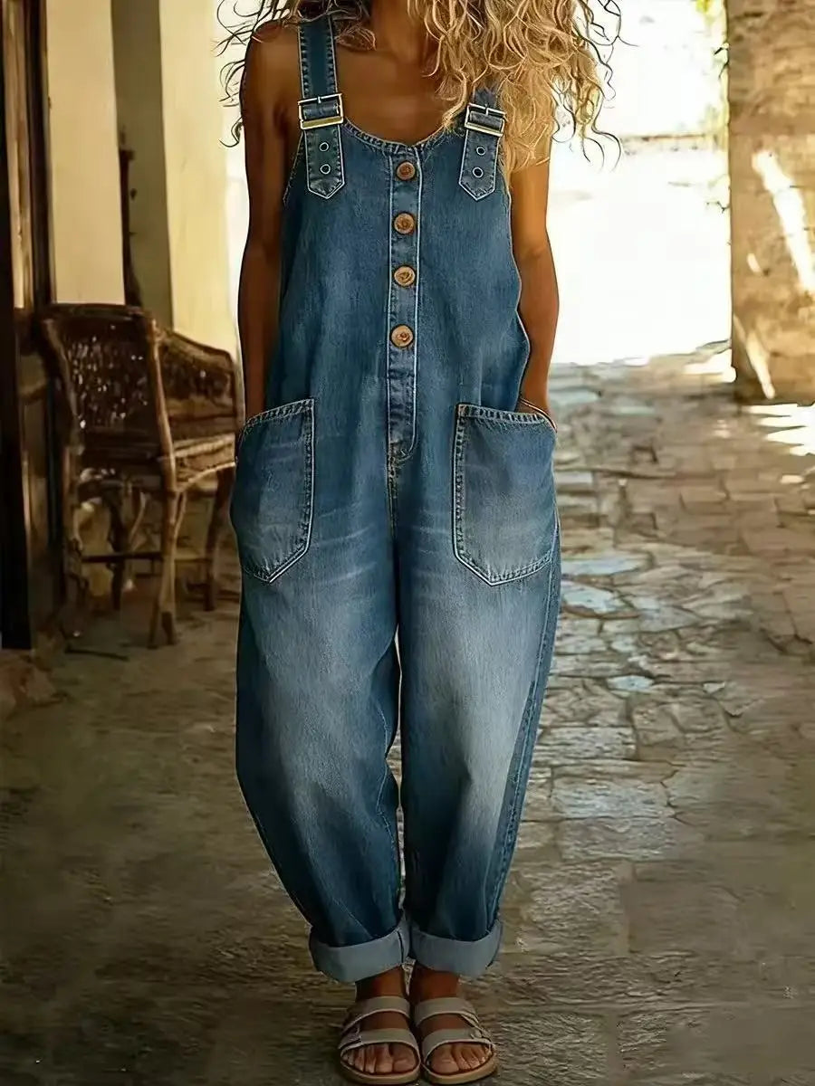 Blue denim bib overalls with adjustable straps, front buttons and side pockets, worn by a woman with blonde hair.