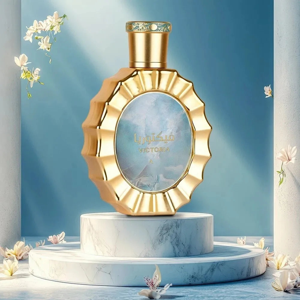 Golden round perfume bottle with a fluted rim on a marble pedestal against a blue background with white flowers.