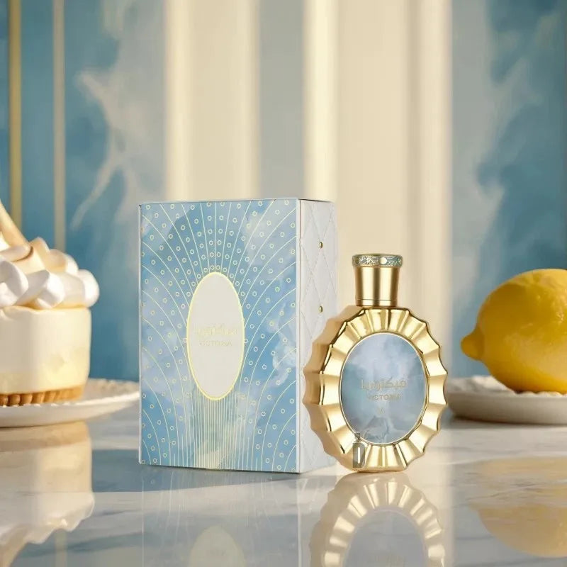 Perfume bottle and its matching blue box on a marble surface with a lemon and dessert.
