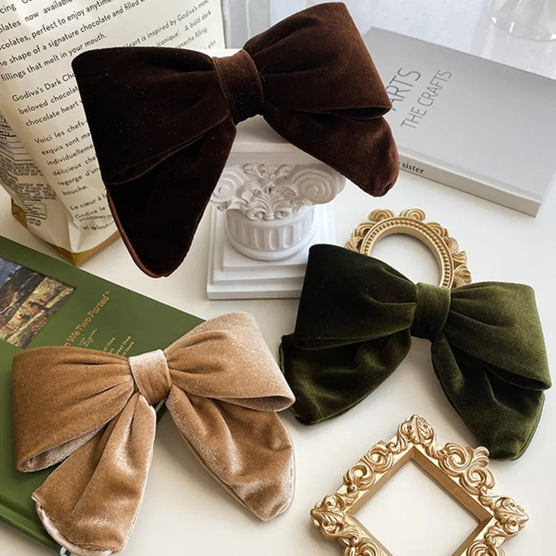 Set of velvet bow hair clips in various colors including brown, olive green, and tan