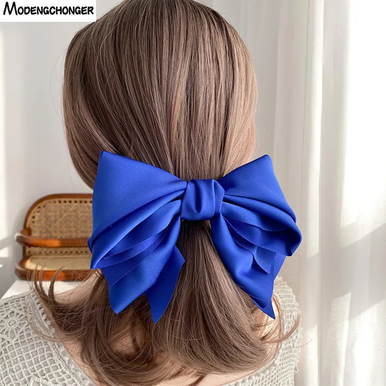 A woman wearing a large blue satin bow hair clip