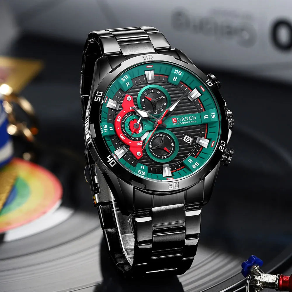 Black stainless steel chronograph watch with a green and red dial on a dark background.