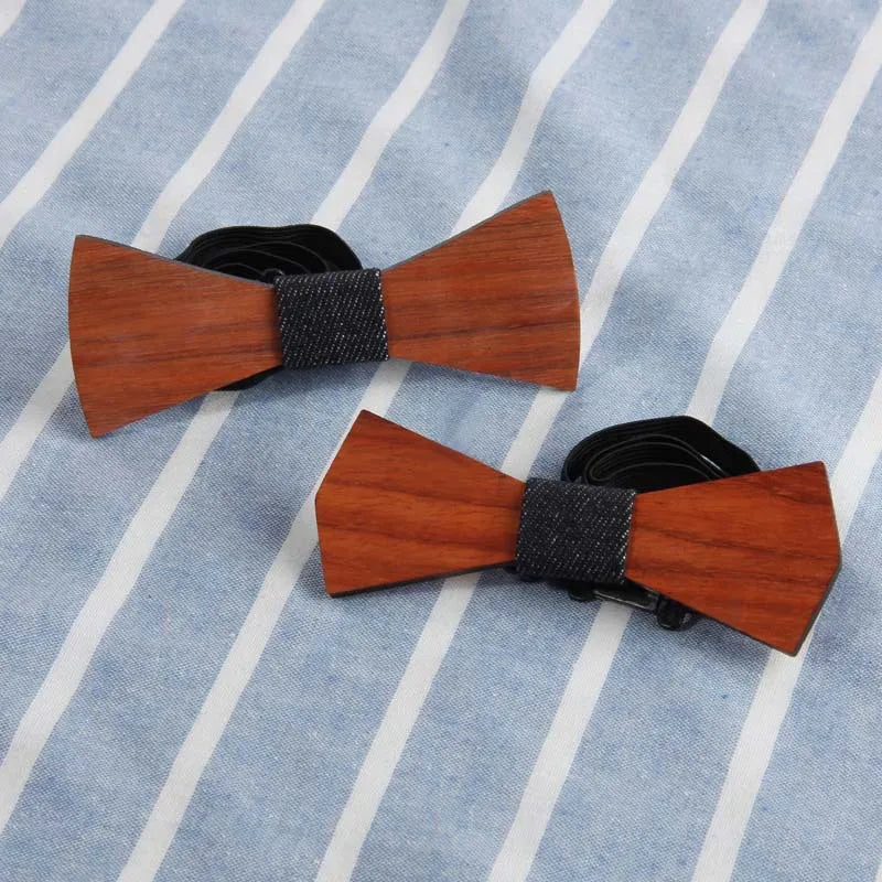 Two wooden bow ties on striped fabric background