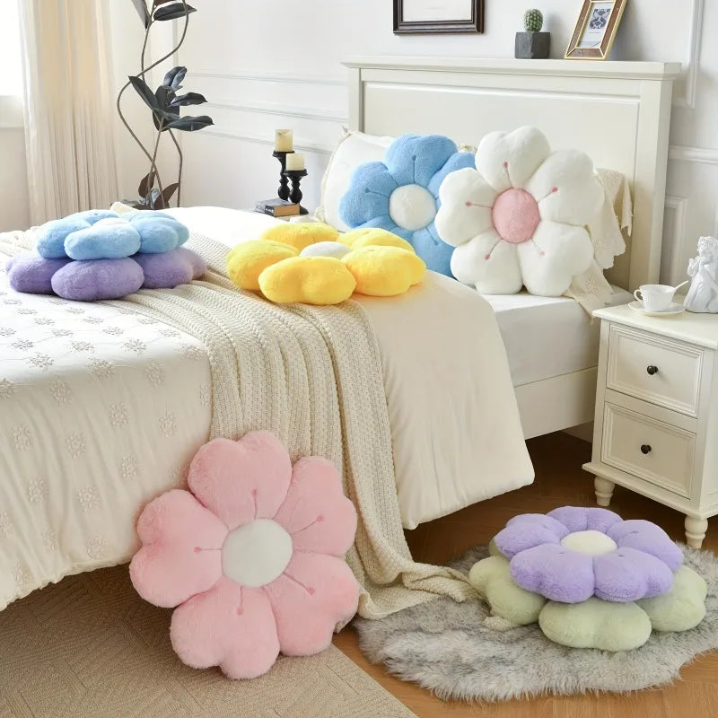 Multiple colorful plush flower-shaped pillows scattered on a bed.