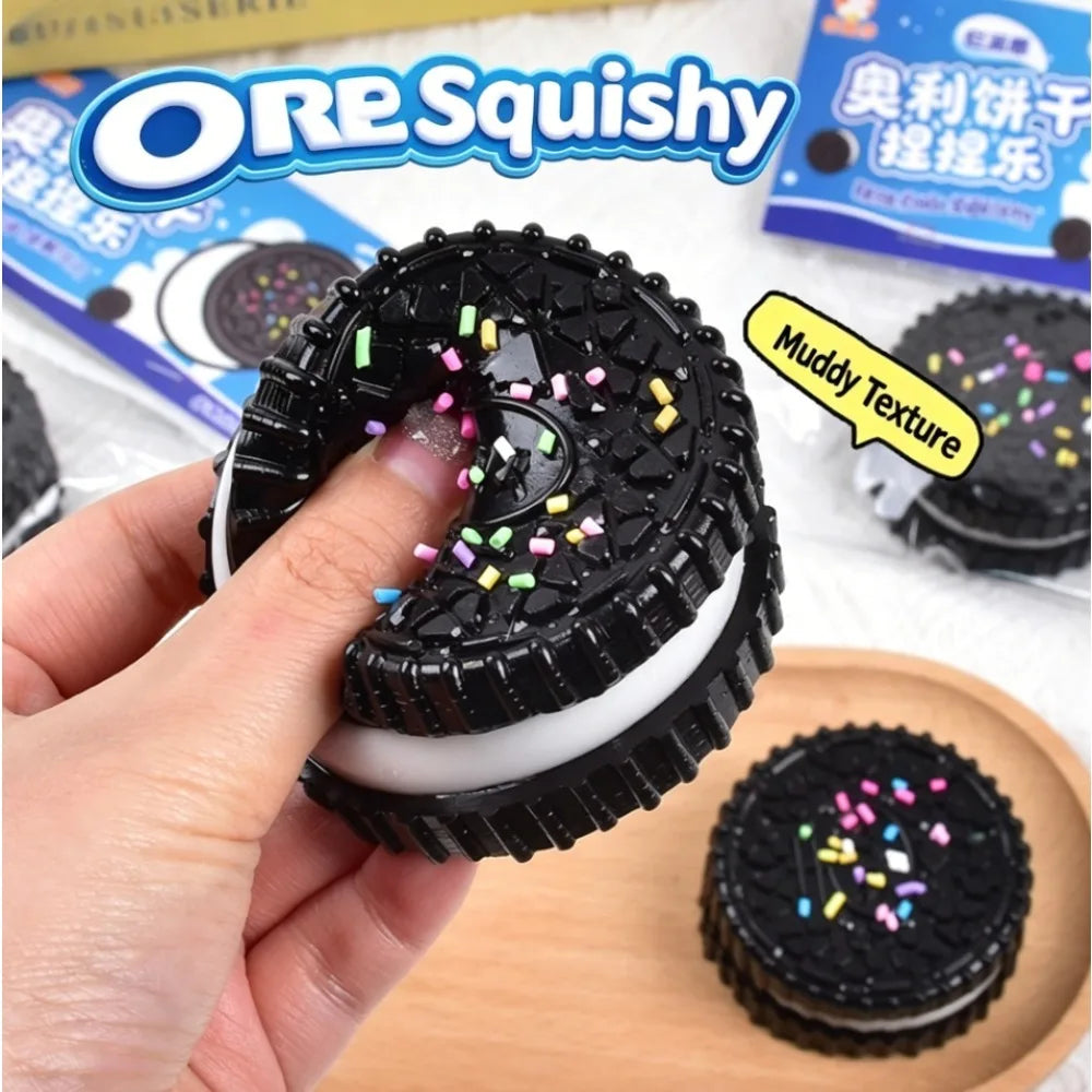 A black and white cookie-shaped stress relief squishy toy being squeezed.