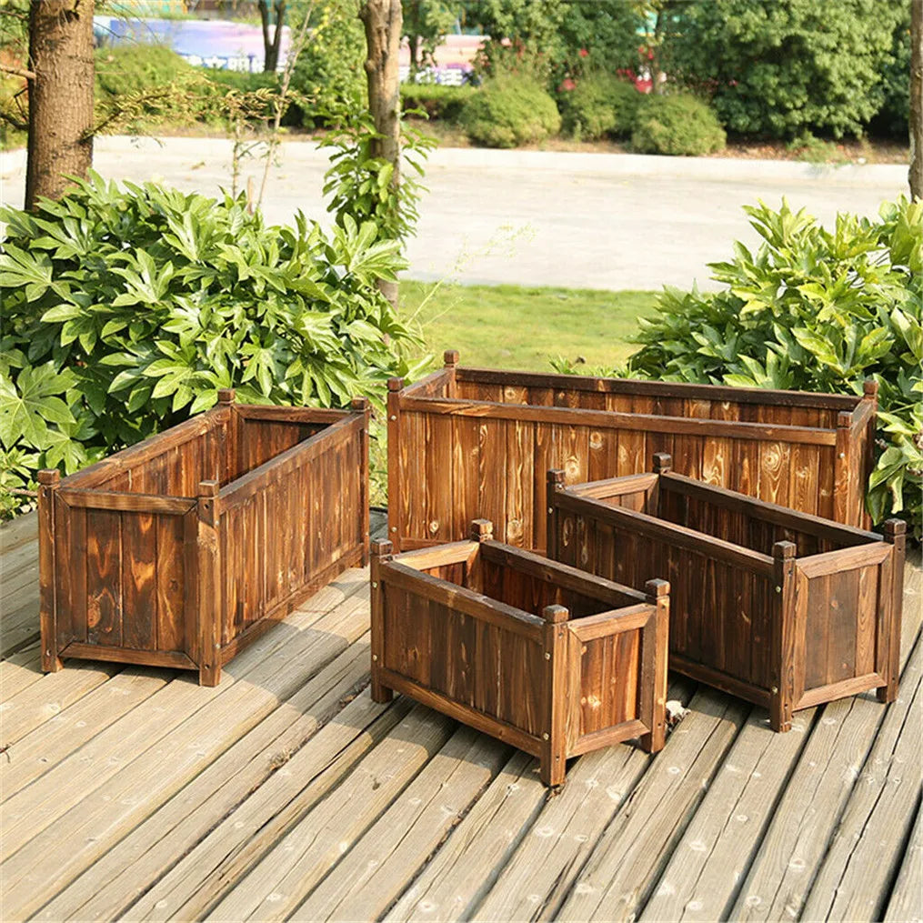 Three rustic wooden plant boxes of different sizes set on a wooden patio floor