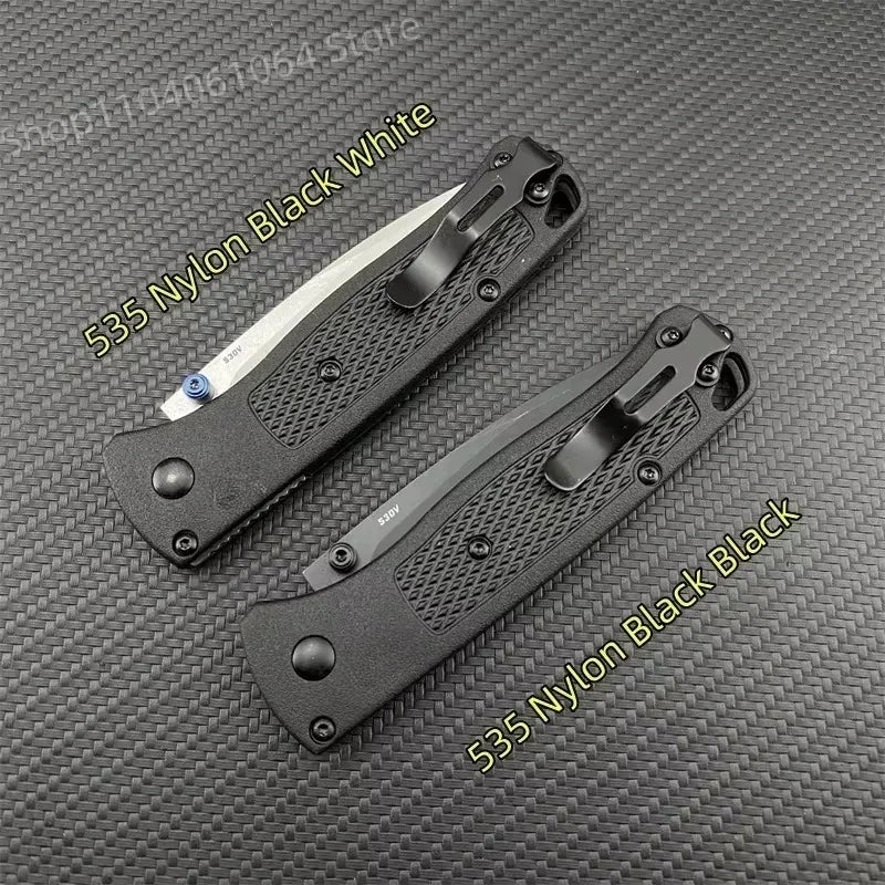 Two folding pocket knives with black handles and metal clips, one with a silver blade and one with a black blade.