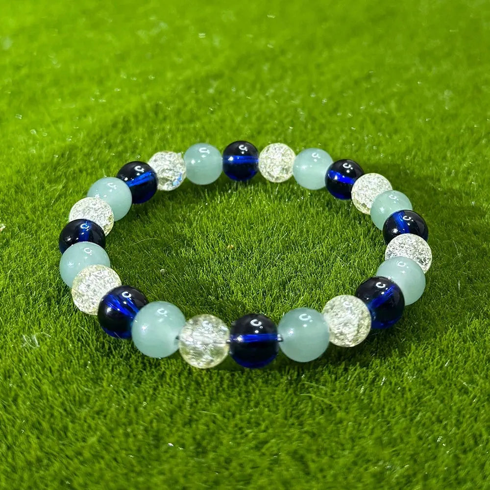 Beaded elastic bracelet with blue, light green and crackled clear beads on green moss