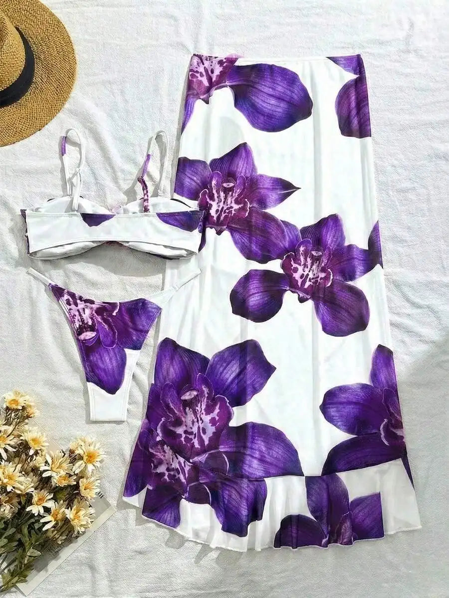 A white bikini set with purple floral print and 3D orchid detail