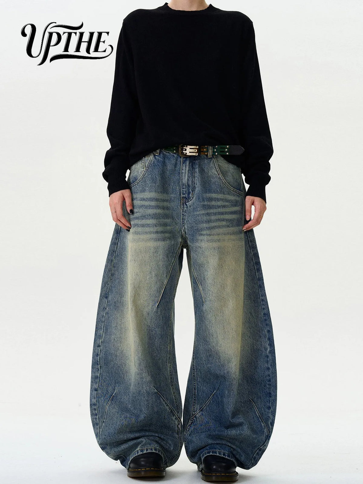 Model wearing vintage washed baggy wide leg denim jeans with black belt and shirt