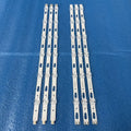 A set of six white LED backlight strips for television repair laid out on a blue surface.