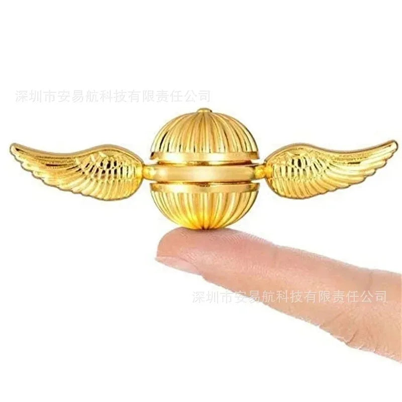 Golden snitch inspired fidget spinner toy being held between two fingers