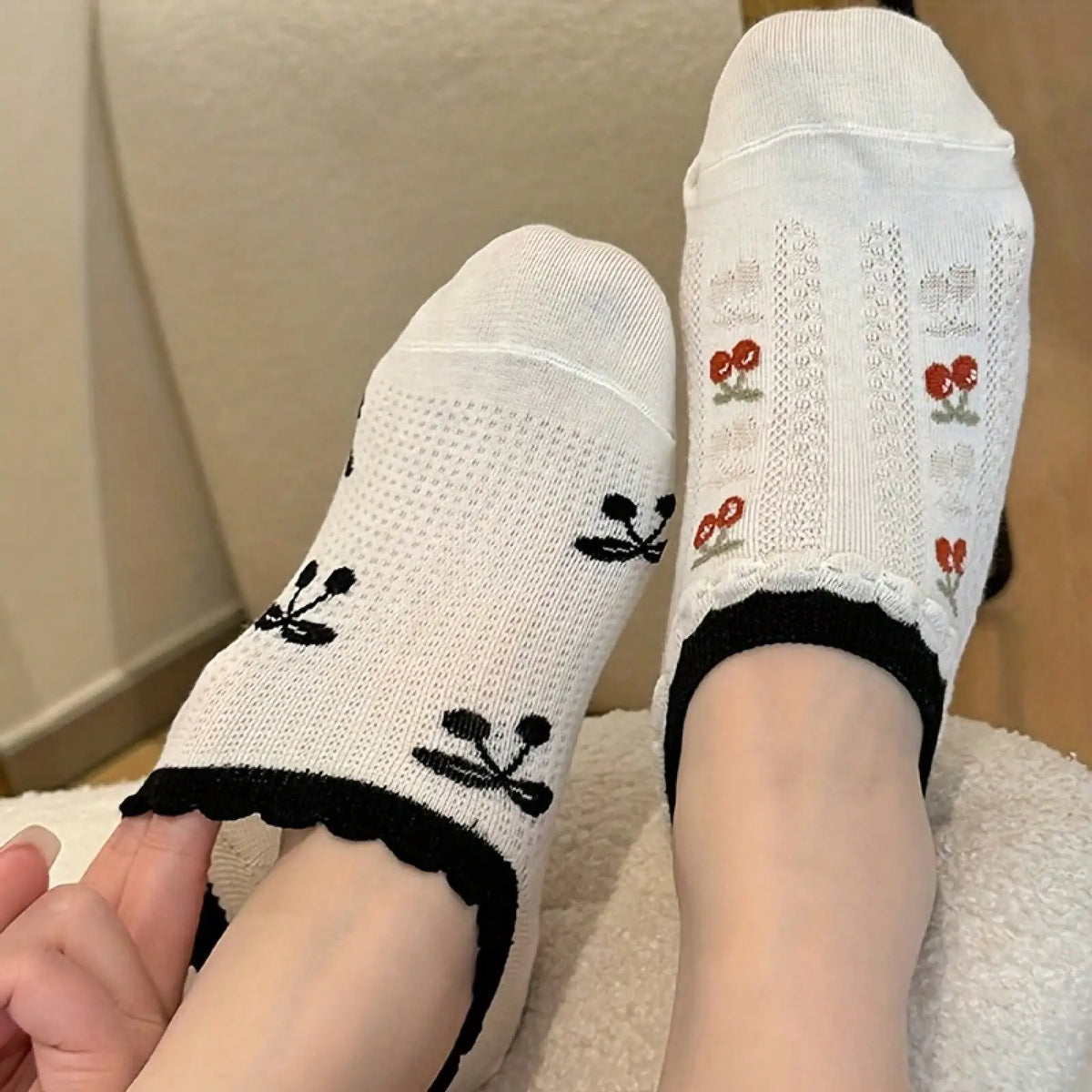 A person wearing white ankle socks with cherry patterns