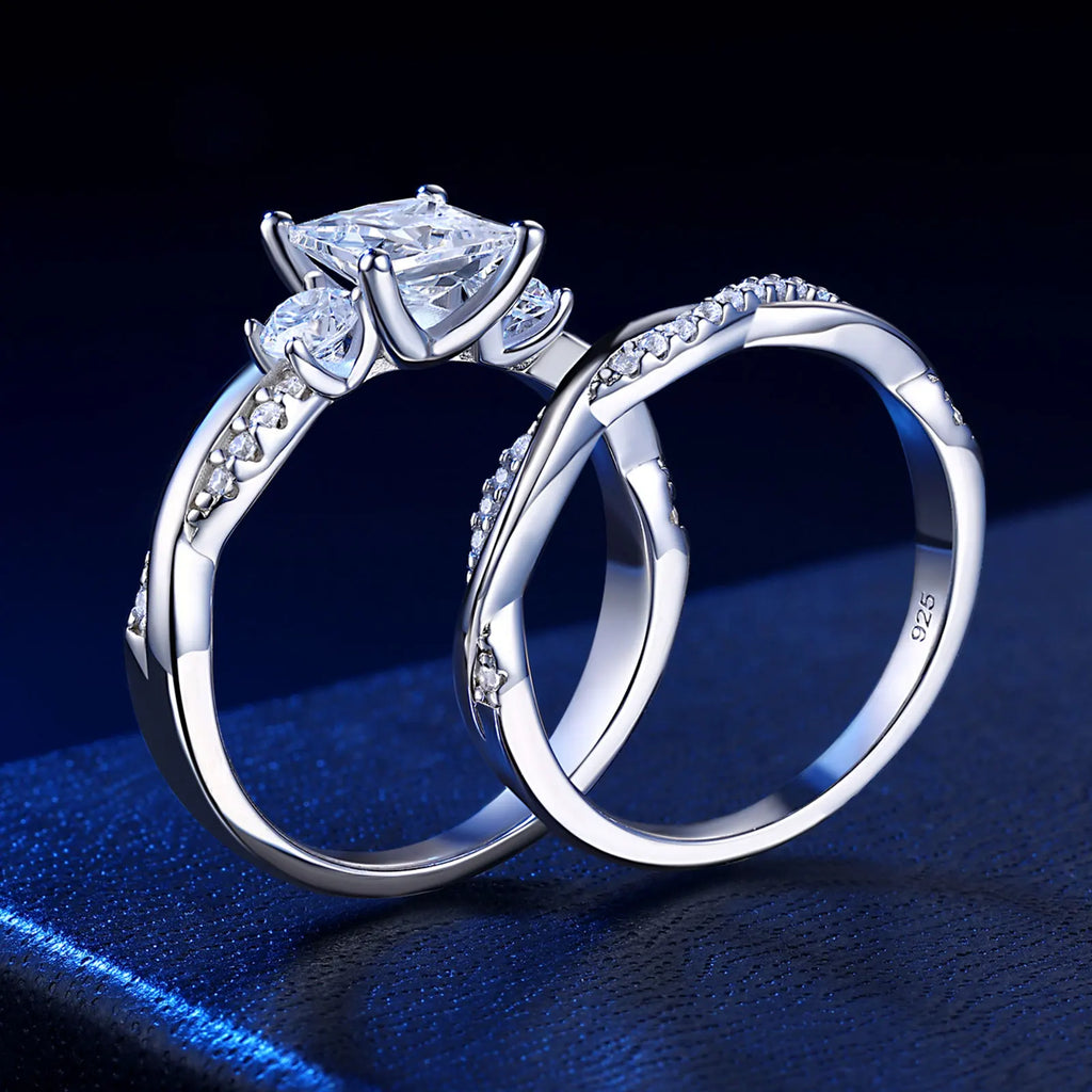 Silver princess cut engagement ring set on dark background