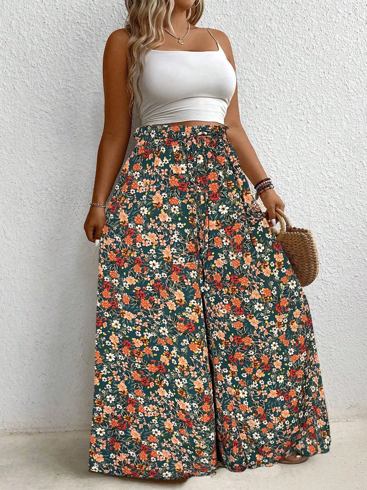 High waisted floral print wide leg pants with an elastic drawstring waist in green, orange, and white.