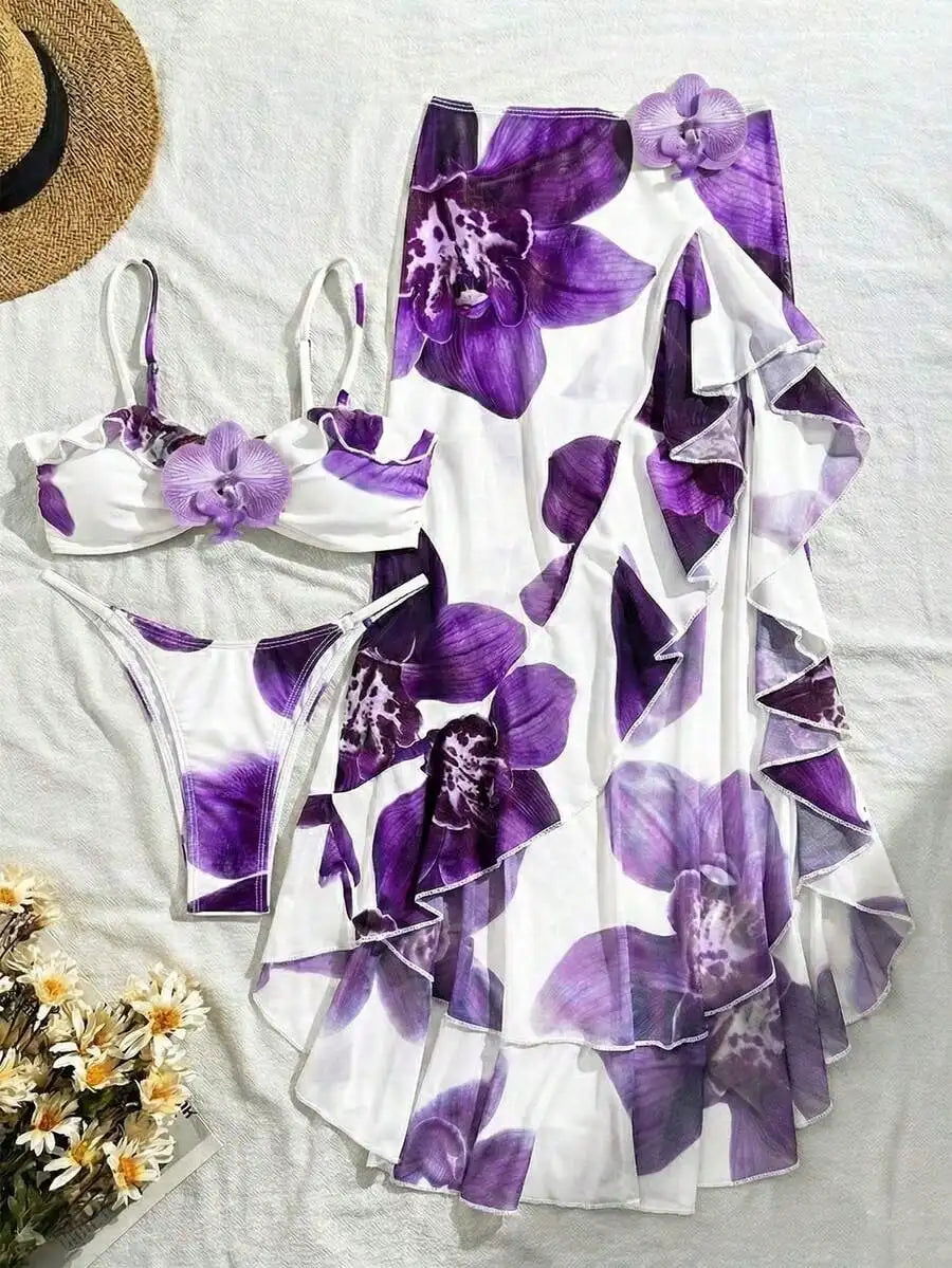 A three-piece bikini set including a floral bikini top with 3D orchid, matching bikini bottoms and a floral sarong