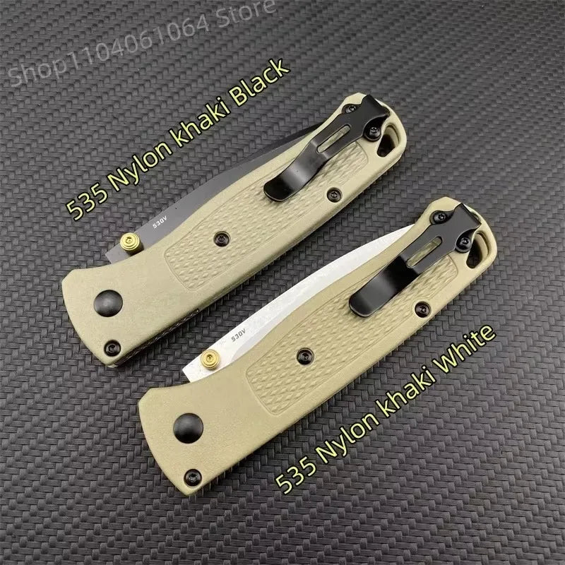 Two folding pocket knives with tan handles and metal clips, one with a black blade and one with a silver blade.