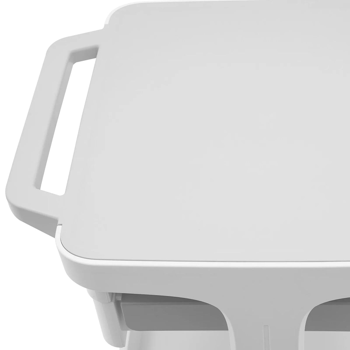 Close-up of the top shelf and handle of a white mobile storage cart