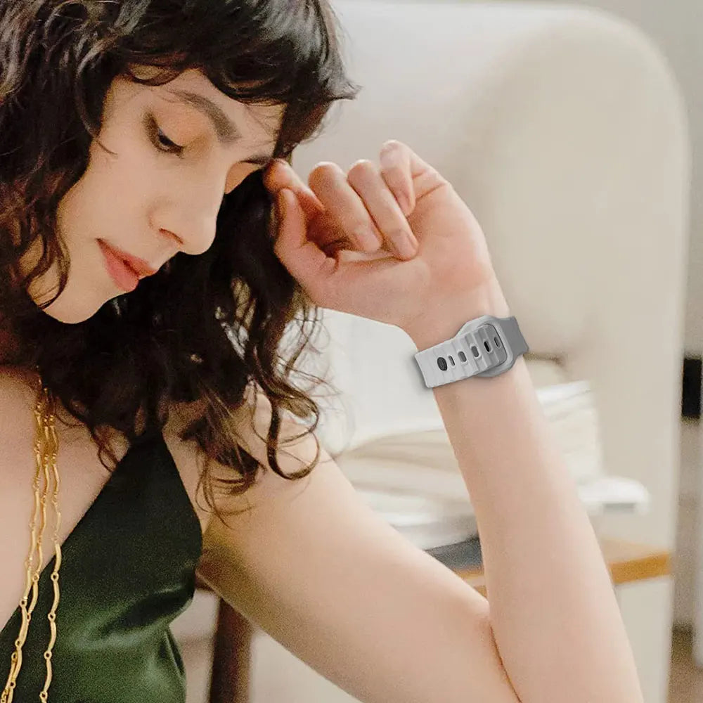 Person wearing a grey silicone watch strap on their wrist.
