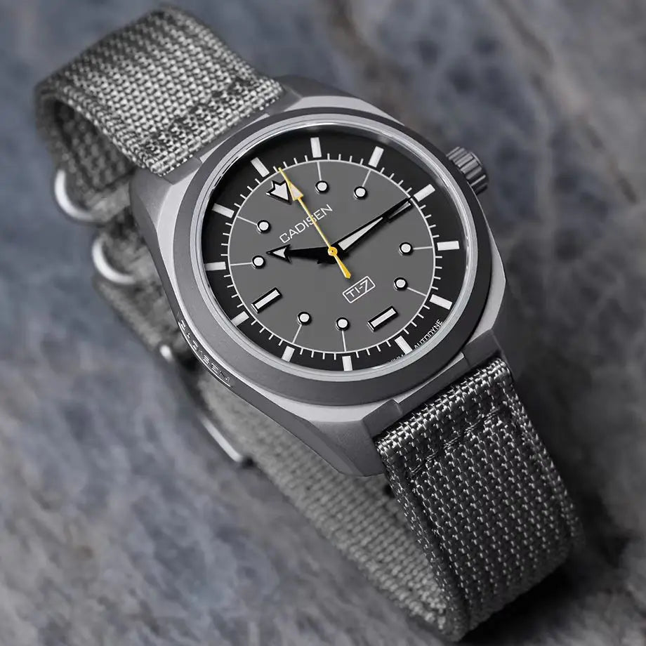 Angled view of a grey titanium automatic watch with a grey canvas nato strap