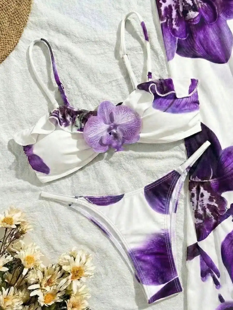 A white bikini top with purple floral print and 3D orchid detail