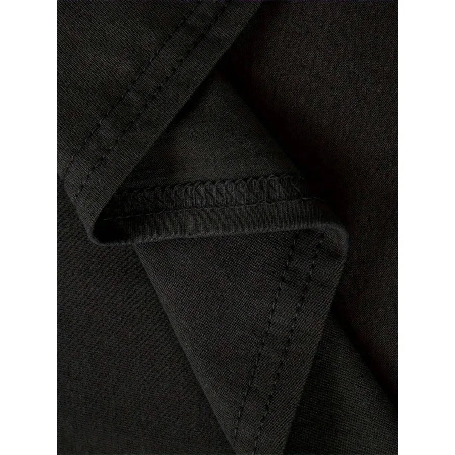 Close-up of the fabric texture and stitching of a plain black t-shirt.