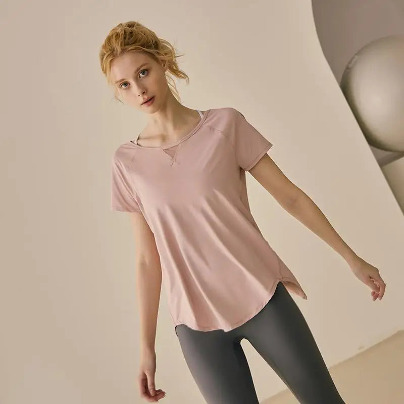 Front view of a woman in a dusty pink short-sleeve yoga shirt with a breathable mesh neckline