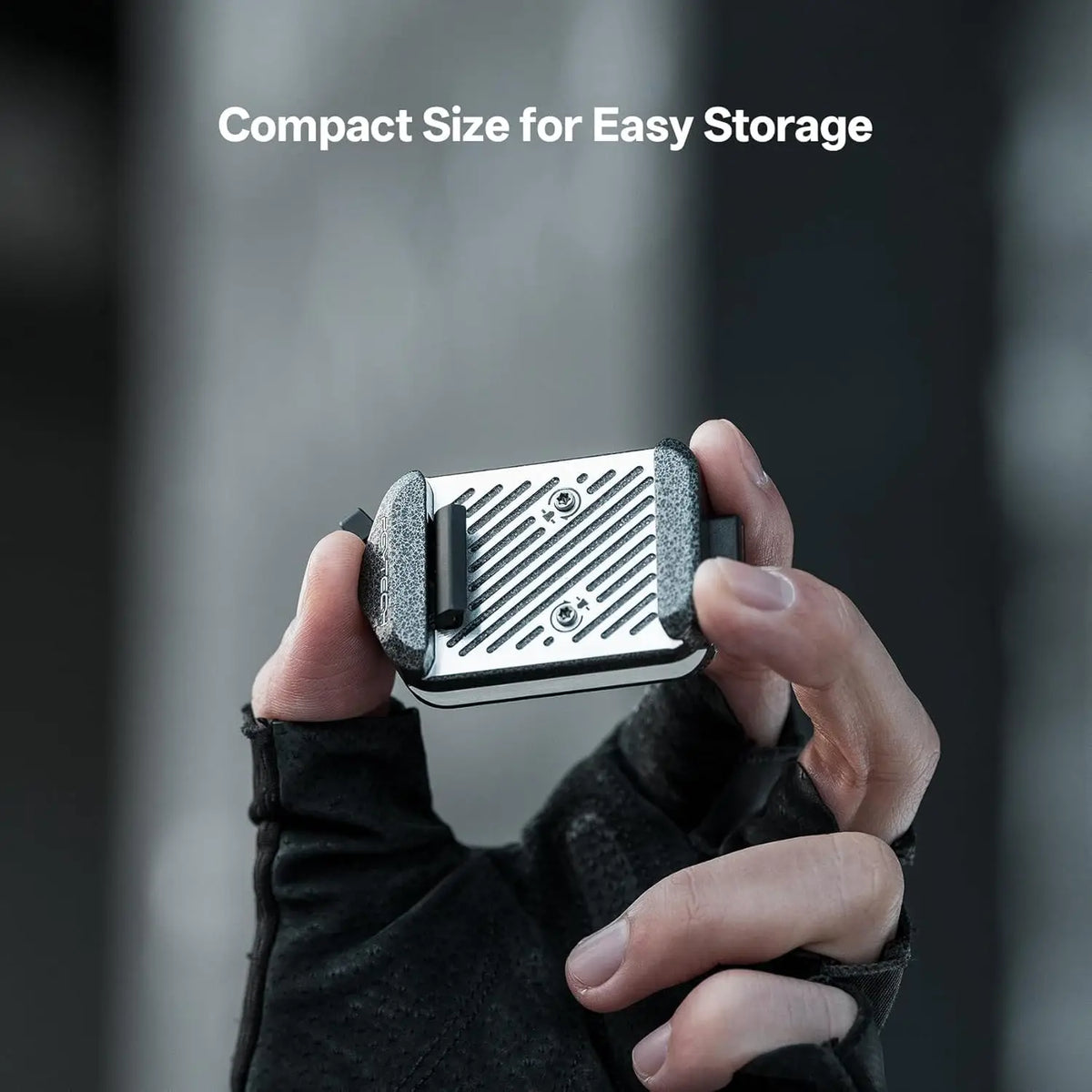 Close up of compact metal quick release plate held by hand