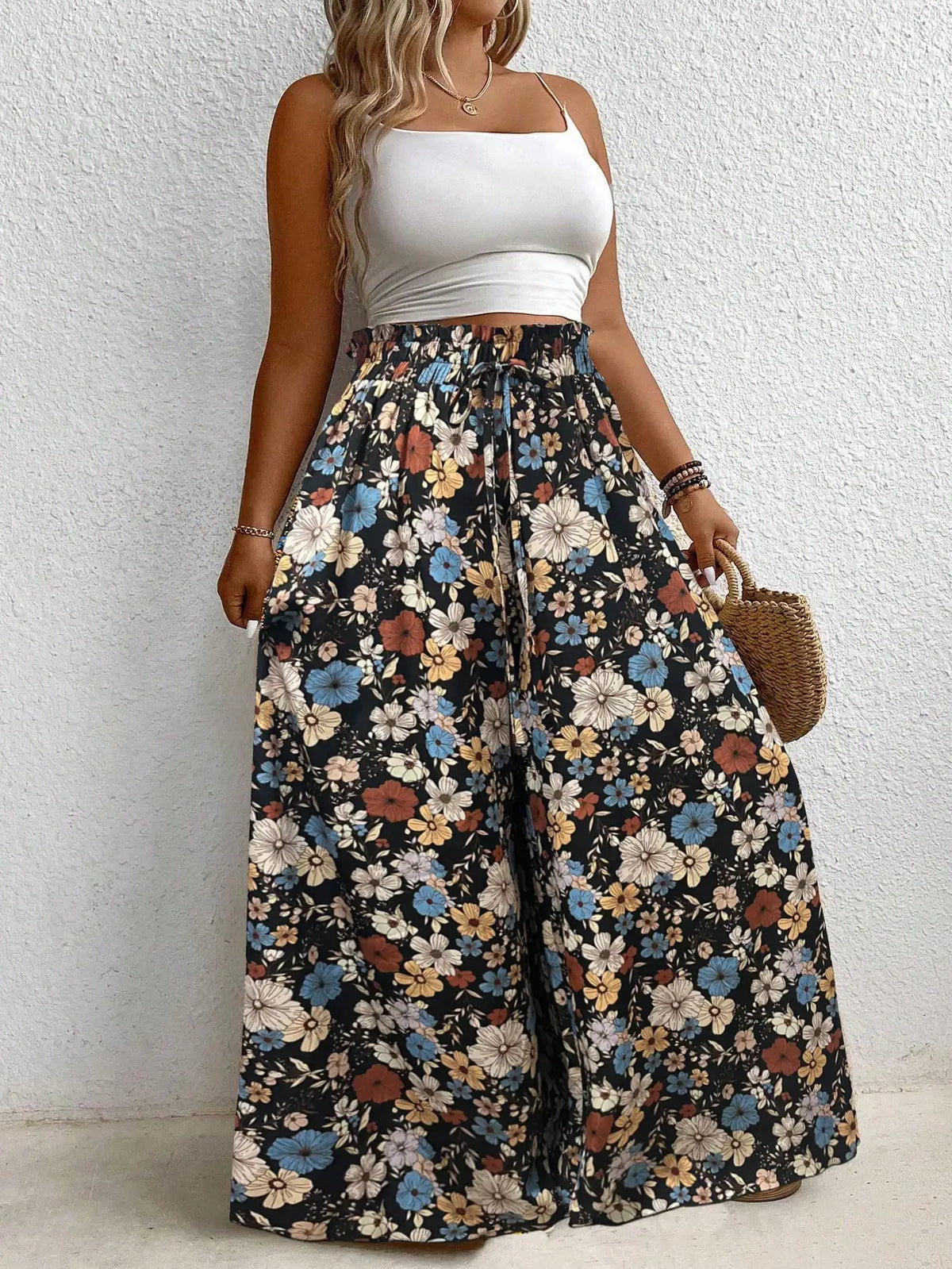 High waisted floral print wide leg pants with an elastic drawstring waist in black, blue, and orange.