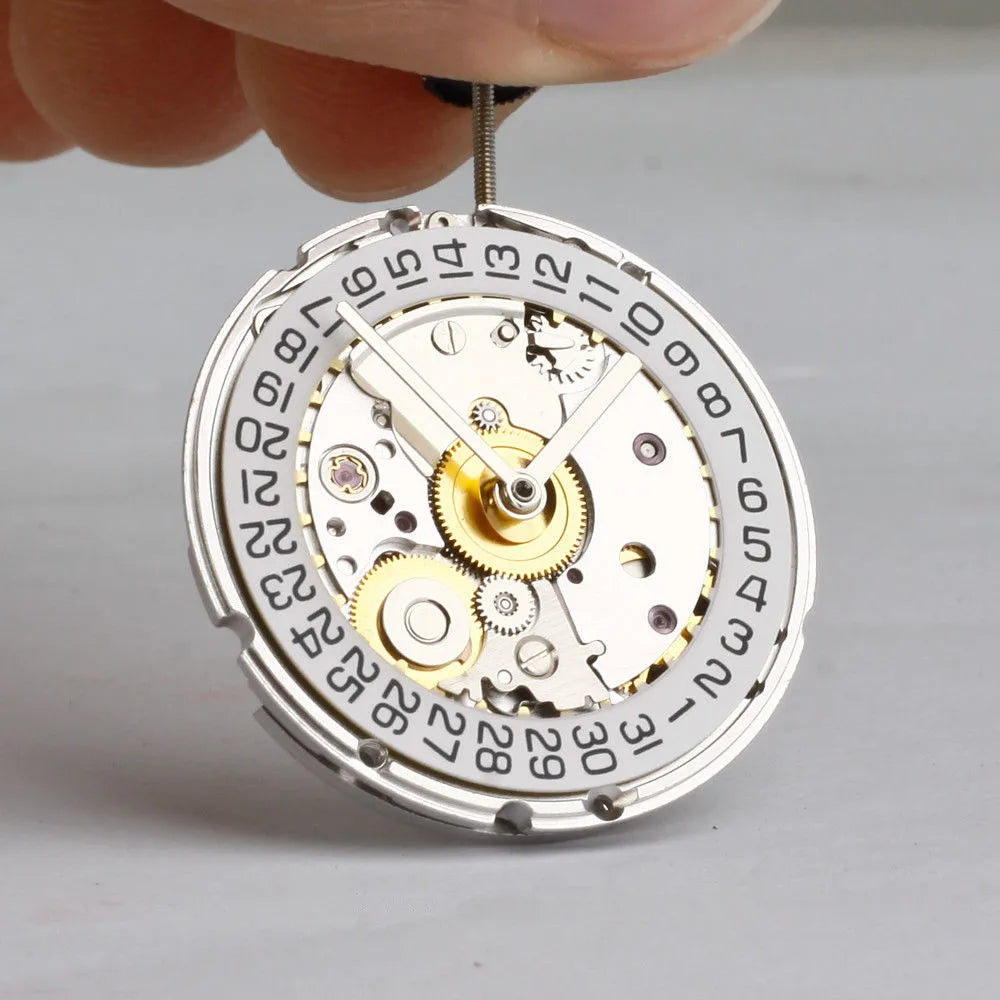 Automatic watch movement being held by hand showing date wheel