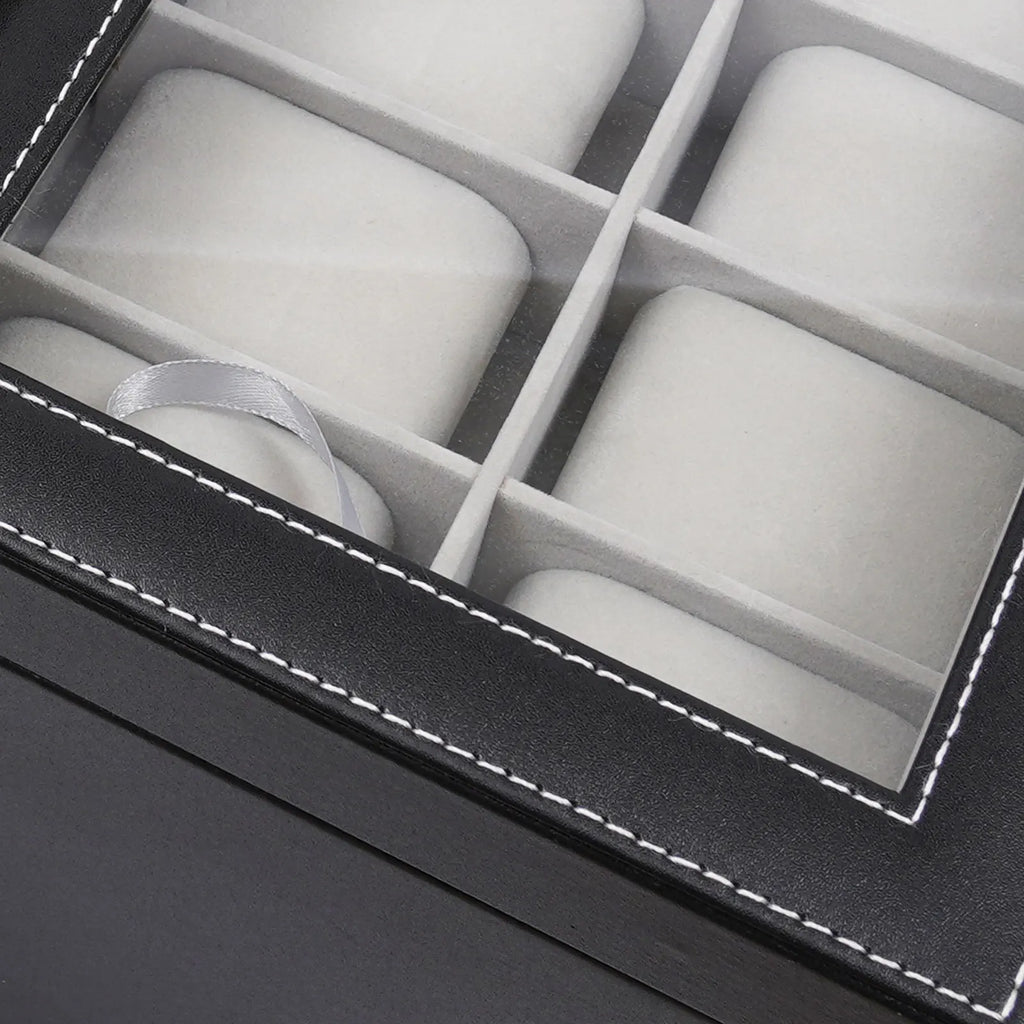 Close up view of the glass lid on a black leather watch display case.