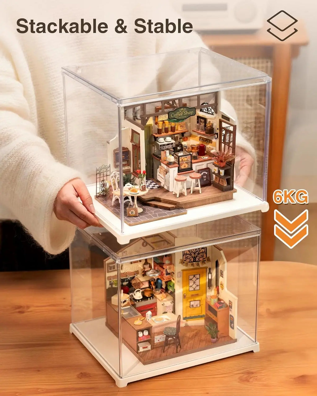 Two clear acrylic display cases stacked on top of each other containing miniature room models