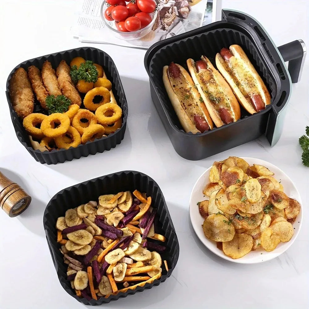 Assorted meals served in black square silicone air fryer liners