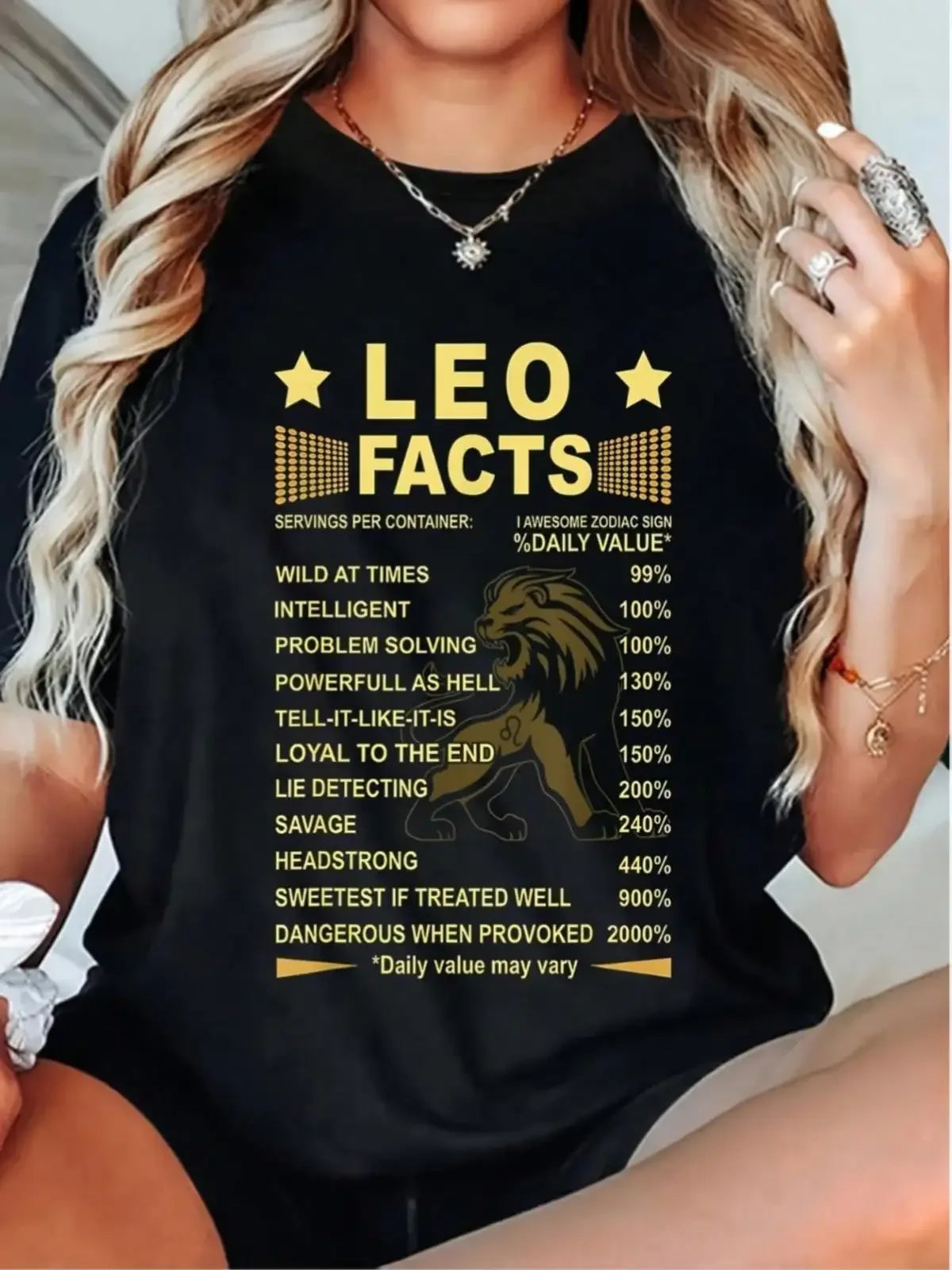 A woman wearing a black t-shirt with a Leo zodiac sign chart and lion graphic.
