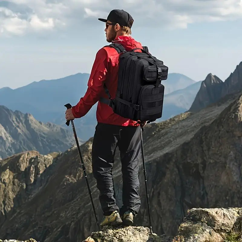 Man hiking in mountains with black tactical backpack