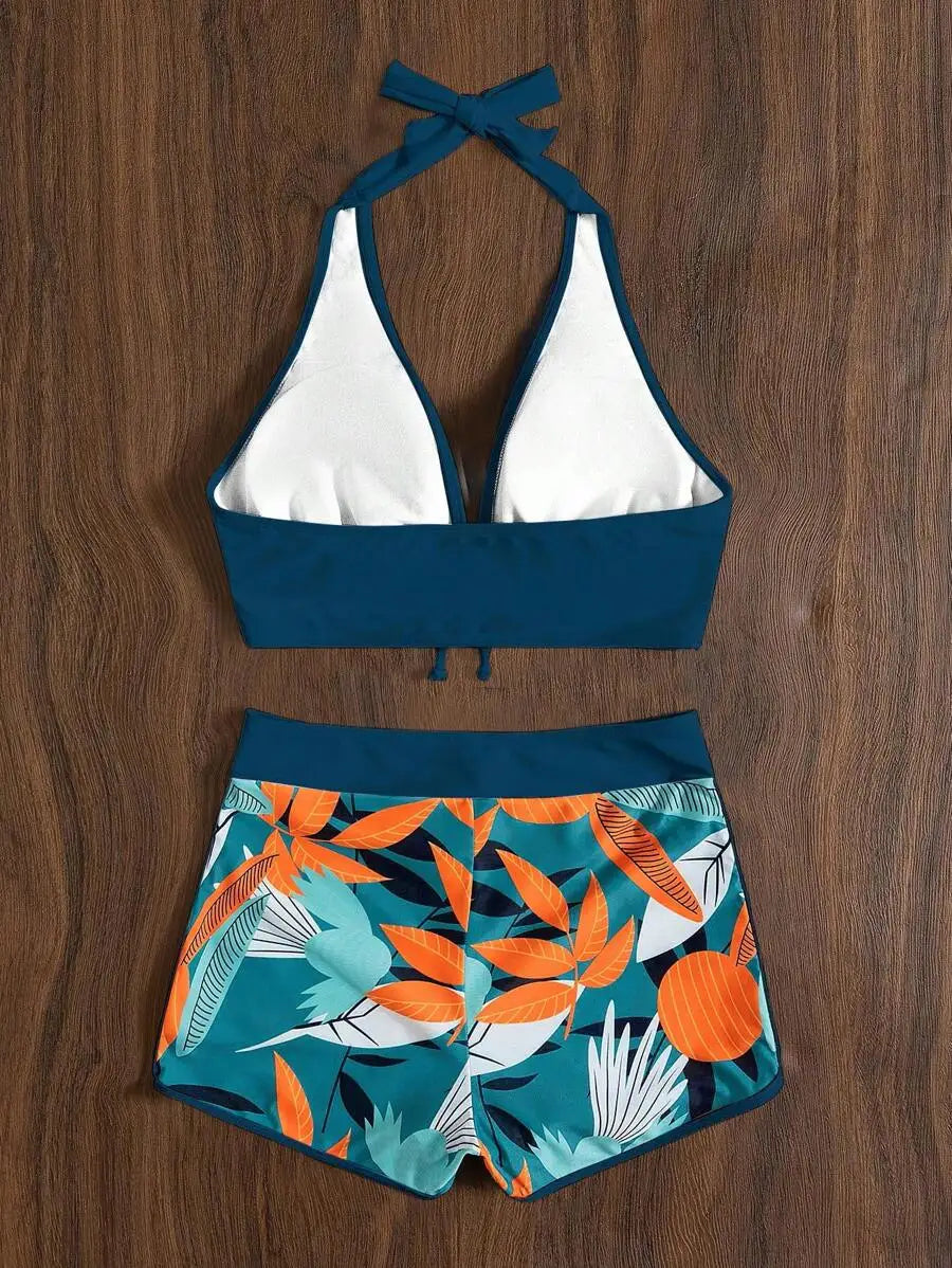 Blue halter bikini top and high-waisted shorts with tropical leaf pattern