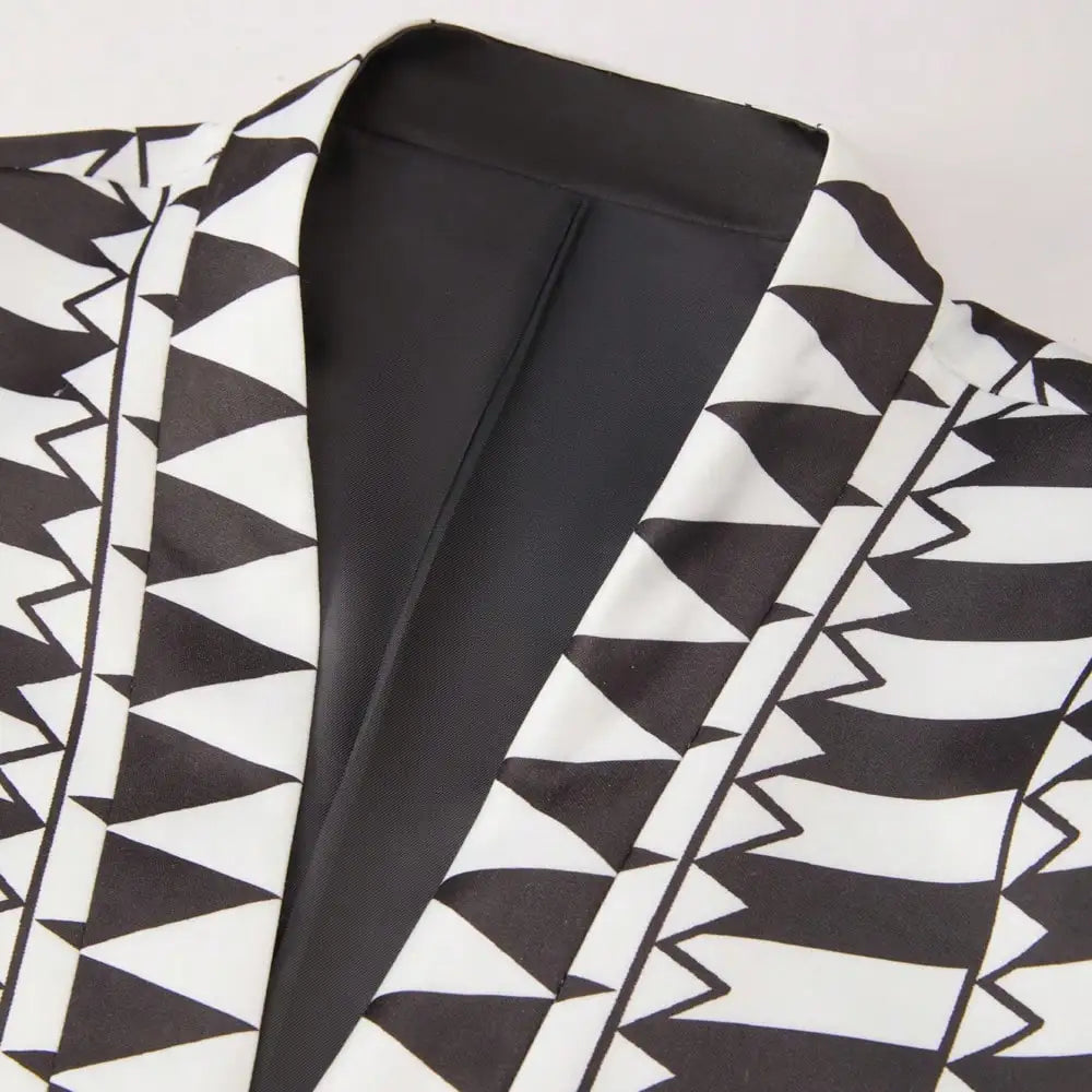 A close-up of the black and white geometric pattern and shawl lapel on a blazer.