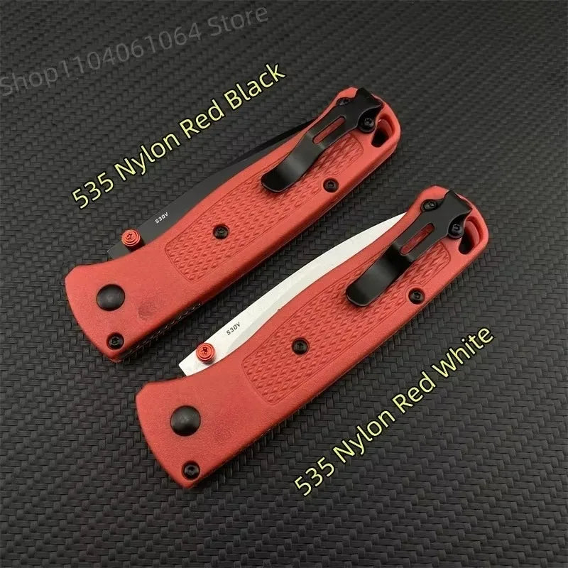 Two folding pocket knives with red handles and metal clips, one with a black blade and one with a silver blade.