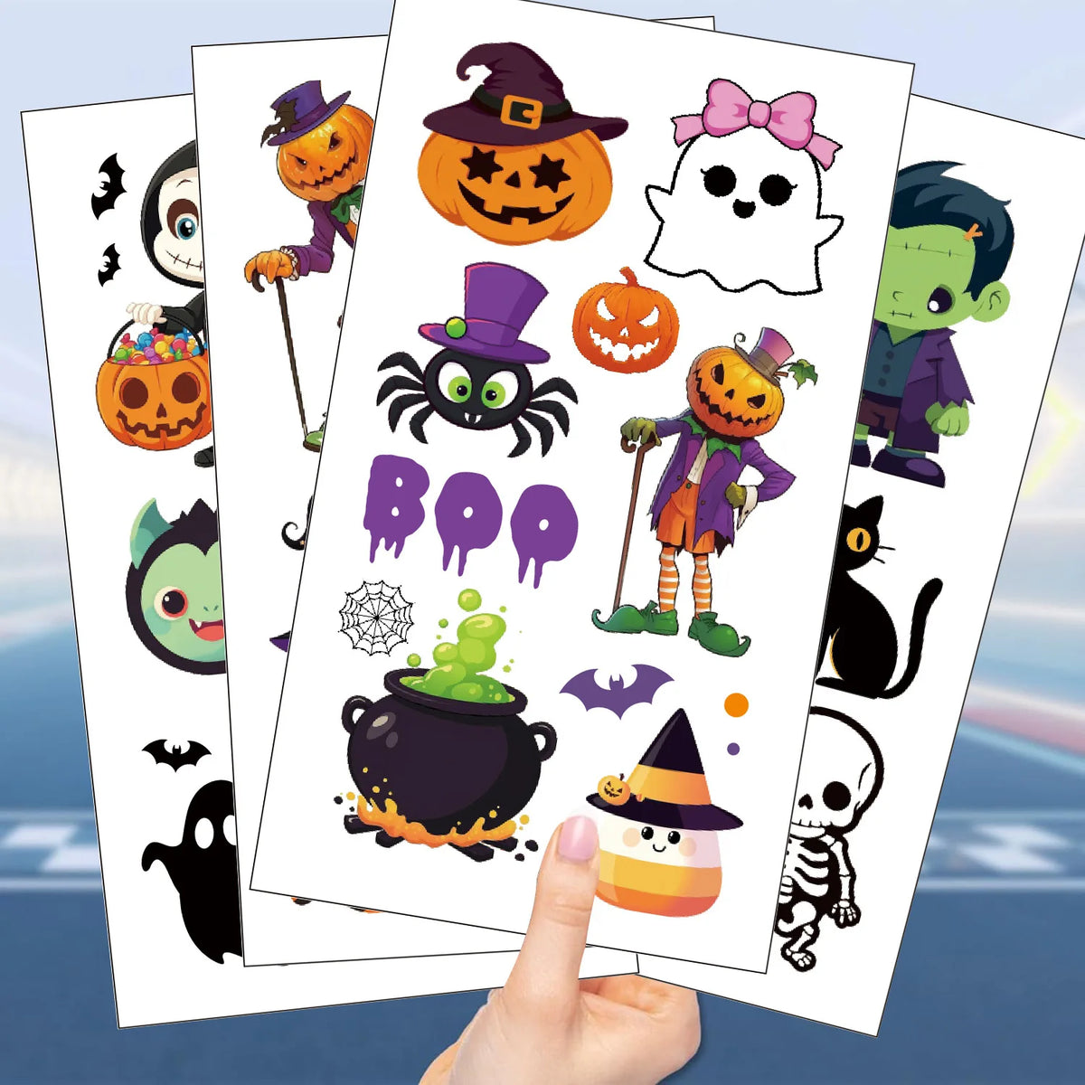 Several sheets of temporary Halloween tattoos featuring cartoon pumpkins, ghosts, and witches held by a hand