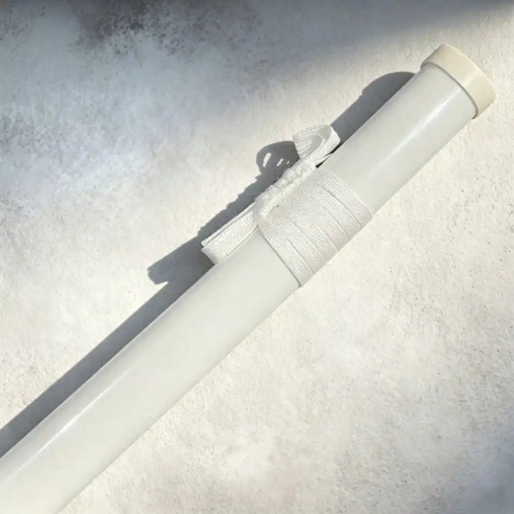 Close-up of white scabbard with white ribbon detail