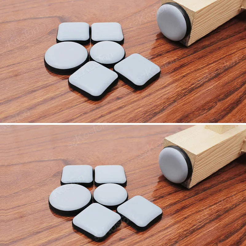 Multiple gray furniture gliders placed on a wooden floor near a table leg