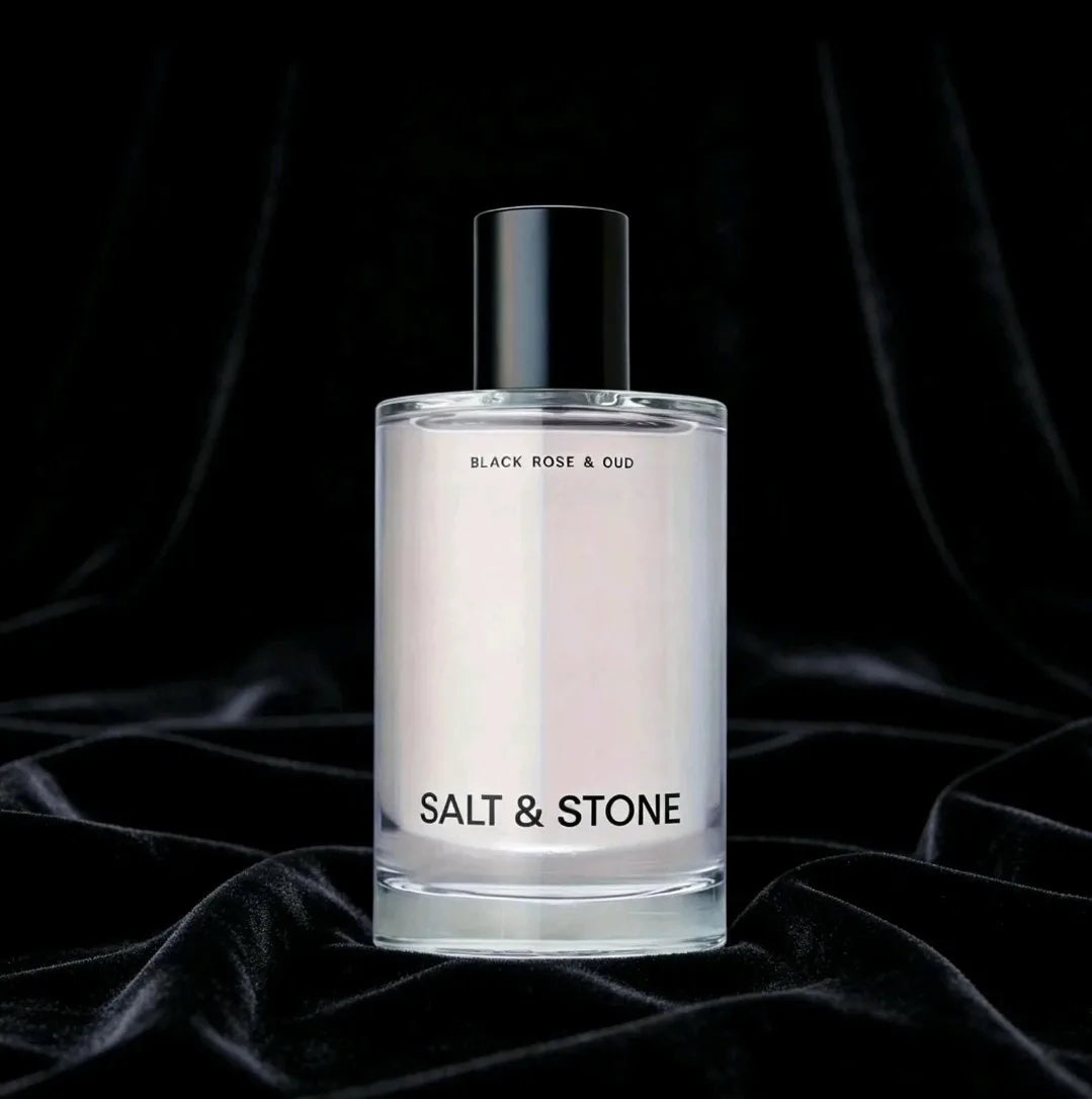 Body mist fragrance bottle set against a black velvet fabric background