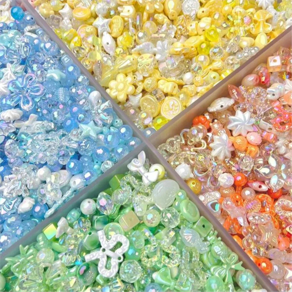 A four-compartment tray filled with yellow, blue, orange, and green colorful craft beads and charms for jewelry making.