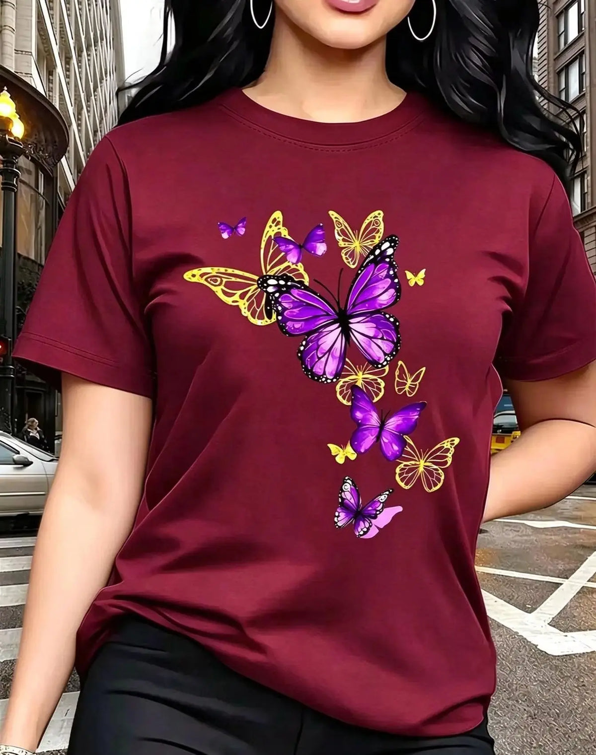 A dark red short-sleeved t-shirt with a printed butterfly design, worn by a woman.