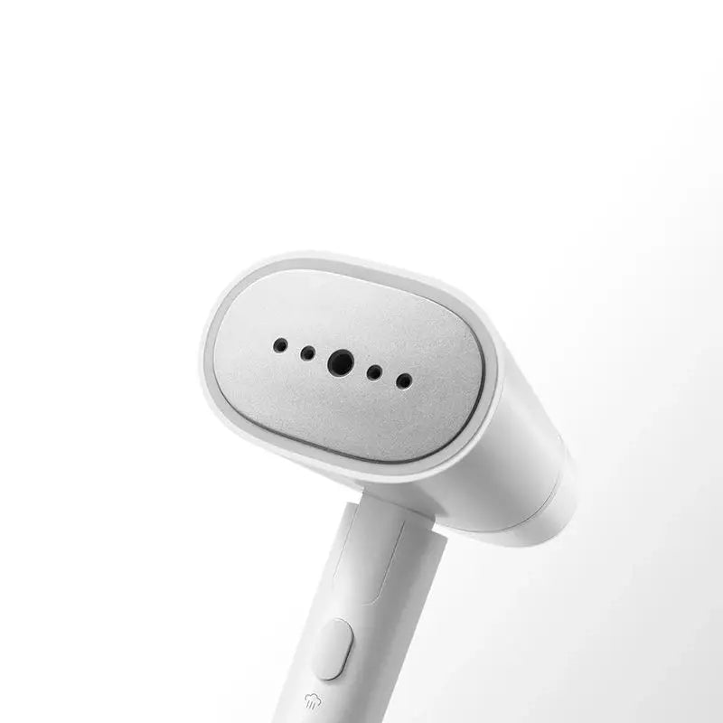Close-up of the steam head of a white portable garment iron.