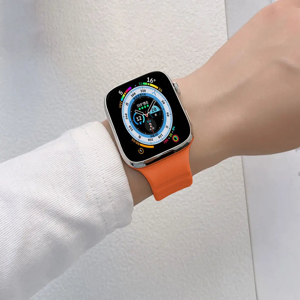 Person wearing an orange silicone watch strap on their wrist.