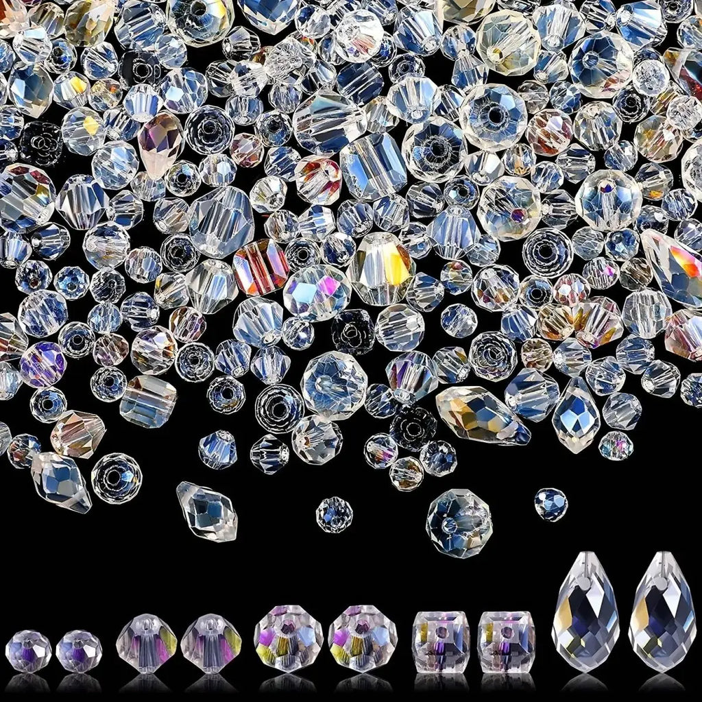 Assorted iridescent clear crystal beads displayed in various shapes and sizes on a black background.