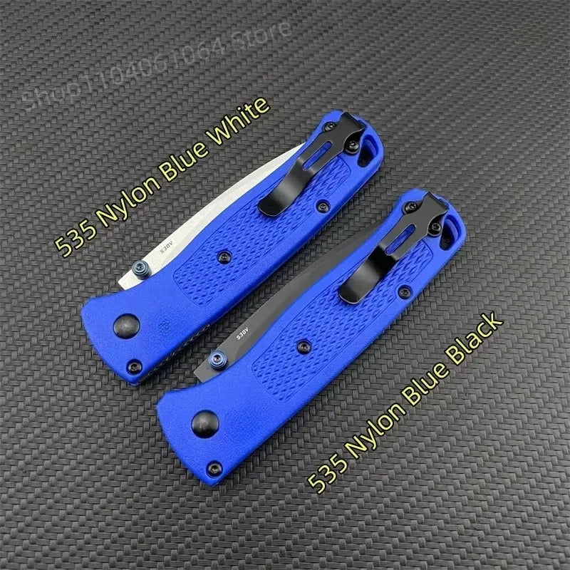 Two folding pocket knives with blue handles and metal clips, one with a silver blade and one with a black blade.