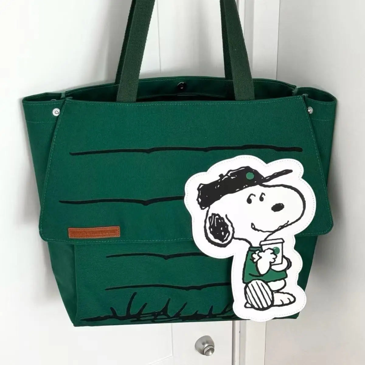 Green canvas tote bag with a Snoopy character patch and black line detailing